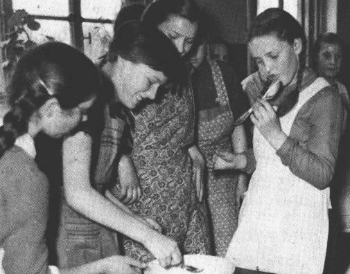 Helga Eikmann, Hannelore Thos, Gisela Appeldorn und im Hintergrund Gesine Brahms schauen zu, wie Christa Bodamer den Teiglffel abschleckt.