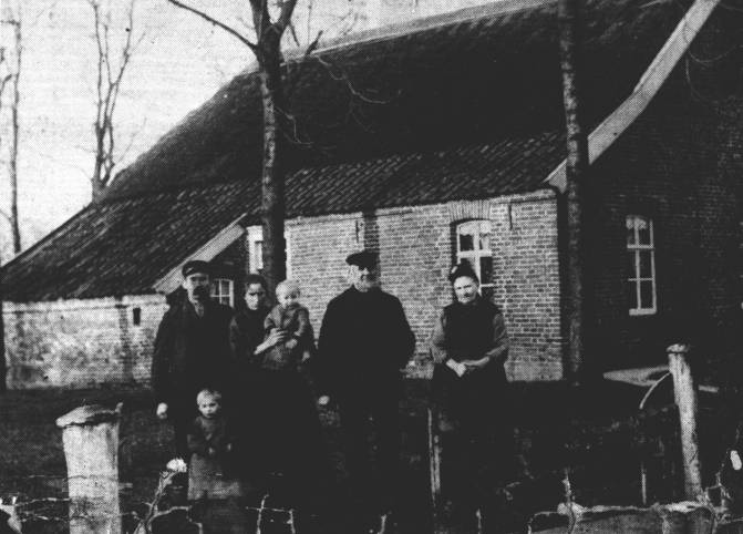 Das Elternhaus auf der anderen Straenseite. Durch den reetgedeckten First konnte das ganze Haus "atmen". Die Dockenpfannen waren noch nicht mit hlzernen Regenrinnen versehen. Rechts stehen Reiner Strenge mit seiner Frau Antje, geb. Kluin. Links steht der junge Oltmann Strenge, der sich als Schmiedemeister auf der anderen Straenseite 1909 selbstndig gemacht hatte. Vor ihm Reinhard und neben ihm Johanne, geb. Kramer, mit Fritz auf dem Arm. Das war vor 79 Jahren ...