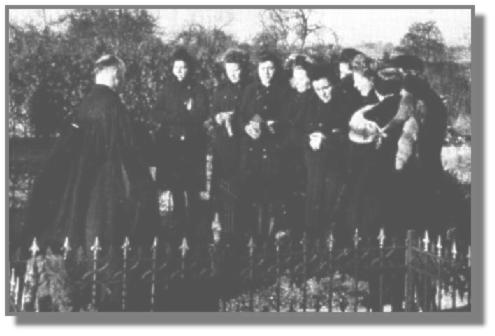 Auf dem Friedhof im Ostrhauderfehner Untenende: Links Pastor Kttner, und rechts die Sngerinnen vom Kirchenchor in ihren schwarzgefrbten Wehrmachtsmnteln. Von links: Erna Taute, Irmgard Krte, Hedwig Hartmann, Anni Eichhorn, Theda Mhlmann, dahinter Martha Dombrowski, Lienchen de Buhr, Anni Neeland und Reenstine Hemmen.