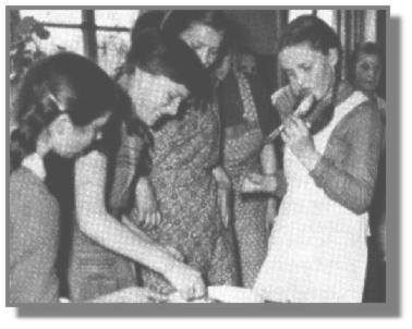 Helga Eikmann, Hannelore Thos, Gisela Appeldorn und im Hintergrund Gesine Brahms schauen zu, wie Christa Bodamer den Teiglffel abschleckt.