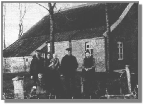 Das Elternhaus auf der anderen Straenseite. Durch den reetgedeckten First konnte das ganze Haus "atmen". Die Dockenpfannen waren noch nicht mit hlzernen Regenrinnen versehen. Rechts stehen Reiner Strenge mit seiner Frau Antje, geb. Kluin. Links steht der junge Oltmann Strenge, der sich als Schmiedemeister auf der anderen Straenseite 1909 selbstndig gemacht hatte. Vor ihm Reinhard und neben ihm Johanne, geb. Kramer, mit Fritz auf dem Arm. Das war vor 79 Jahren ...