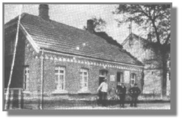 Das Haus von Christian Stapelfeld war an den Winterabenden durch eine Karbidanlage hell erleuchtet. Dieses bislang unbekannte Foto hatte Tini Hoffmann in ihrem Album. Links steht der Schlachter Heinrich Klock, neben ihm der Junge ist Heinrich Stapelfeld, der in Stalingrad gefallen ist. Dann folgt Reinhard von Allen, der Radflicker, und Christian Stapelfeld selbst. Das Haus wurde 1907 gebaut. Rechts ist das alte "Kaufhaus zur Post" zu erkennen (heute Parkplatz). Nach Stapelfelds Tod war hier eine kurze Zeit ein Schuhgeschft, bis dann Jakob Schuver sein bekanntes Fahrradgeschft darin erffnete. Heute steht hier ein Privathaus.